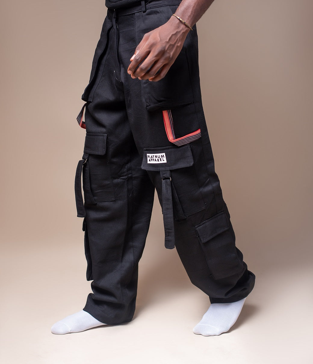 Front view of black men's Cargo Trousers. Stylish and fashionable. With red design detailing and zip closure. Platnum apparel.